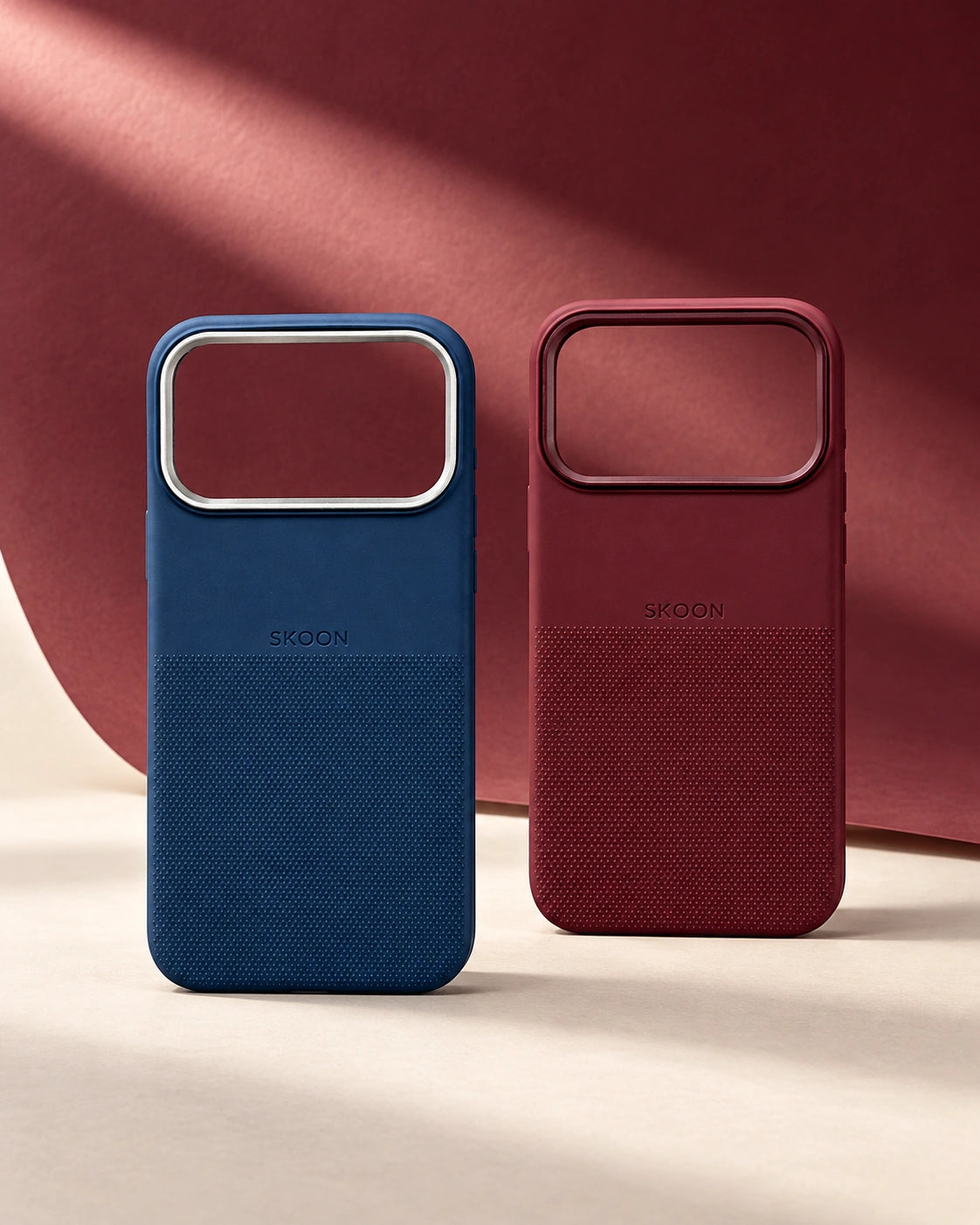 Navy and Burgundy SKOON cases against a sculptural Burgundy paper backdrop
